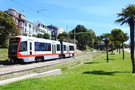 A MUNI passenger train runs along a track in San Francisco.